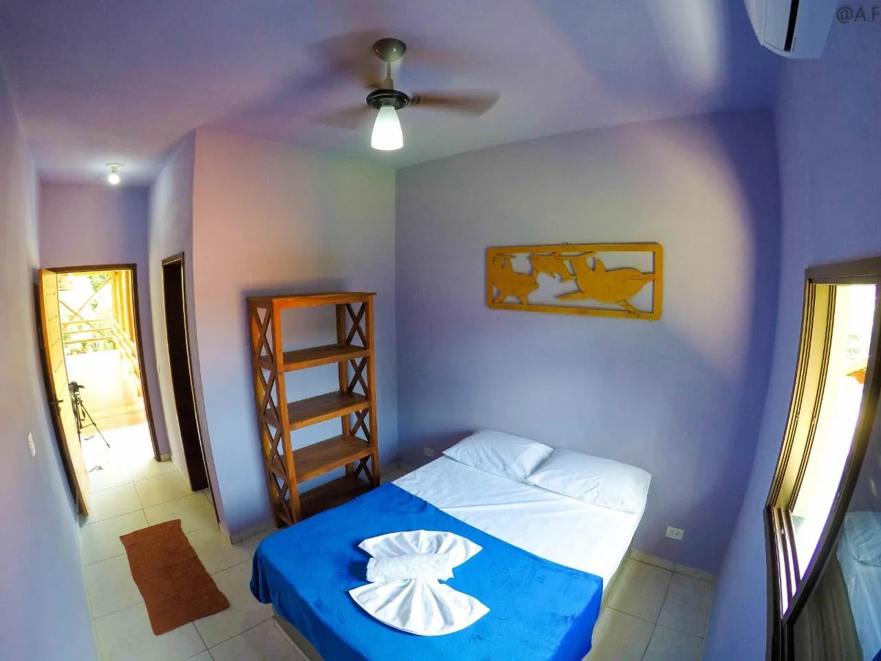 Quarto da Pousada Vibe com cama e decoração em tons de azul
